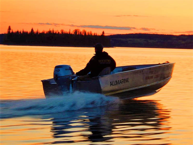 Lac Seul Floating Lodges rental boat on the lake during sunset